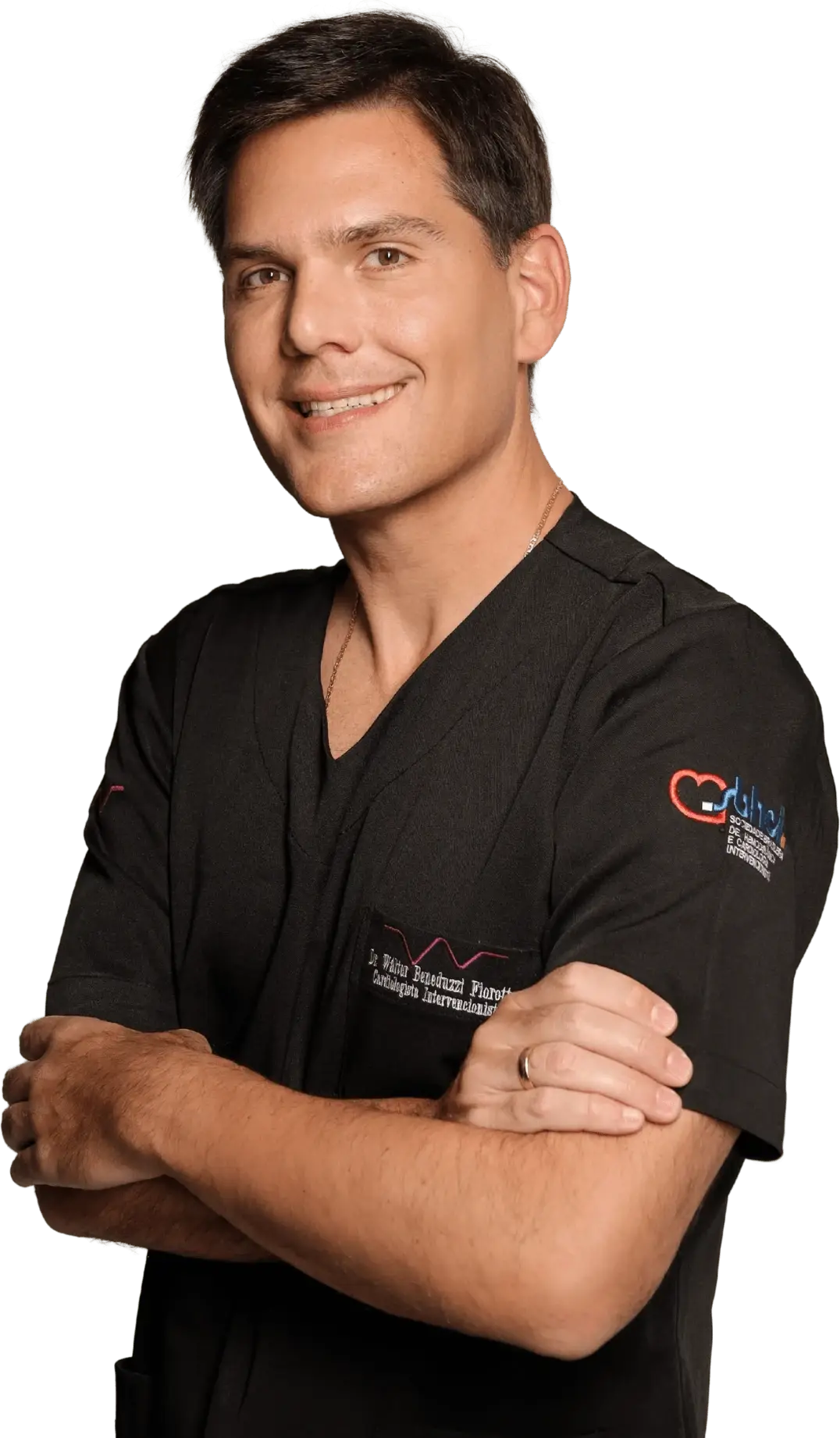 Dr. Walter Beneduzzi Fiorotto sorrindo, de braços cruzados, com roupa de hemodinâmica
